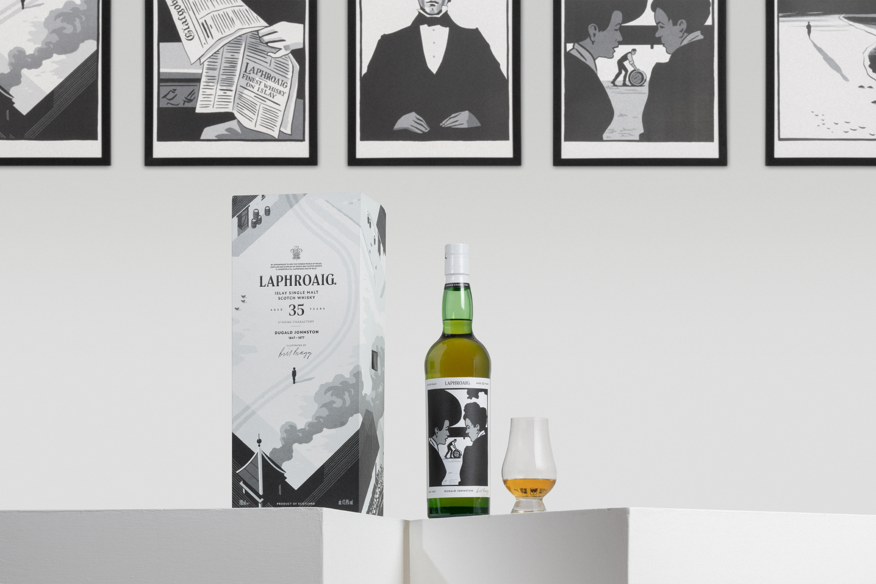 Laphroaig Strong Characters Chapter 2 35-Year-Old whisky, presented with its illustrated packaging and a tasting glass, against a backdrop of framed artwork.