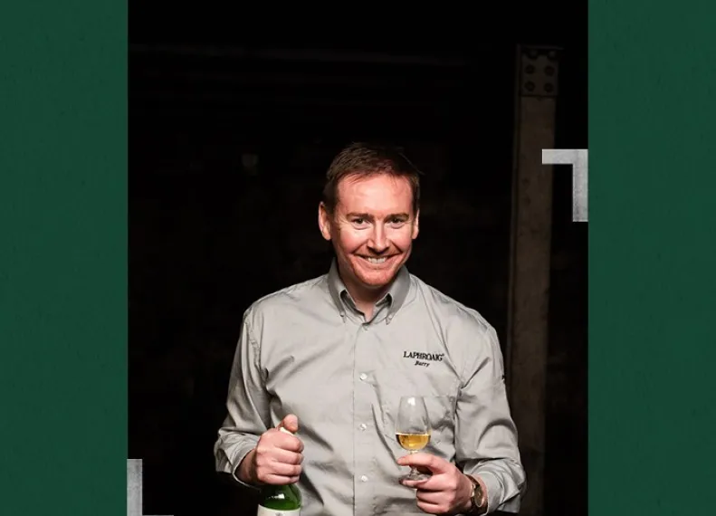 Distillery manager Barry MacAffer holding a bottle and a glass of Laphroaig