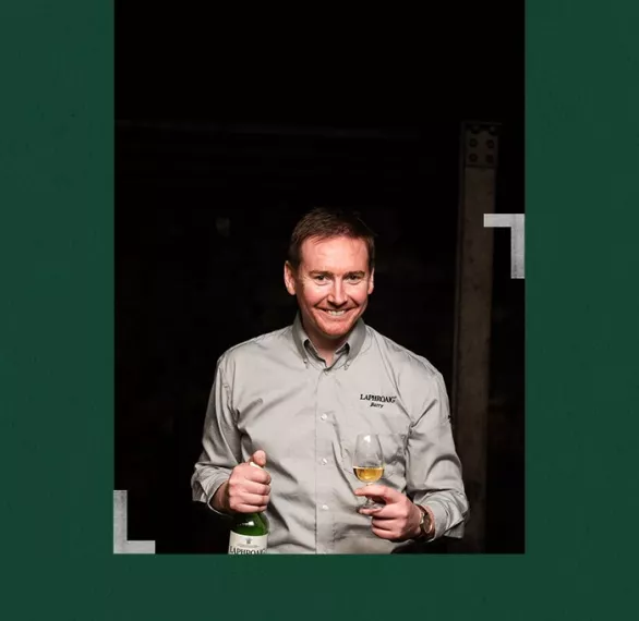 Distillery manager Barry MacAffer holding a bottle and a glass of Laphroaig
