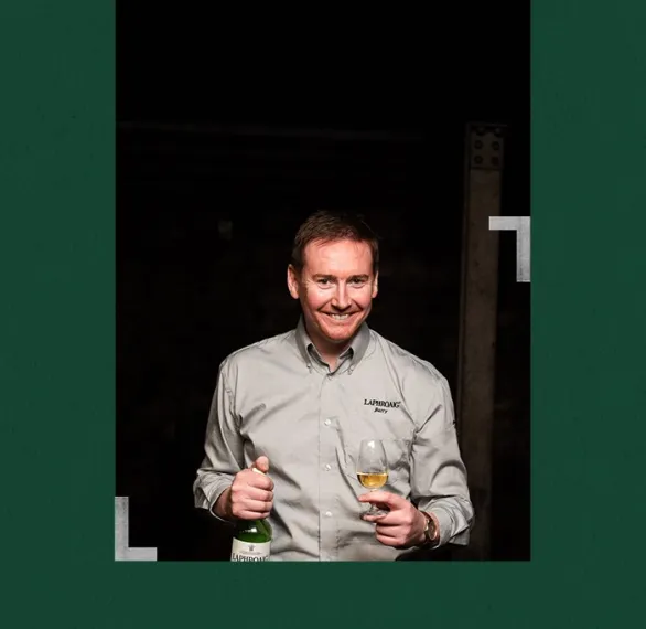 Distillery manager Barry MacAffer holding a bottle and a glass of Laphroaig