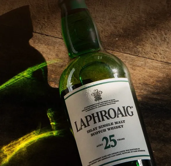 Sunshine hitting a Laphroaig bottle lying on a wooden surface