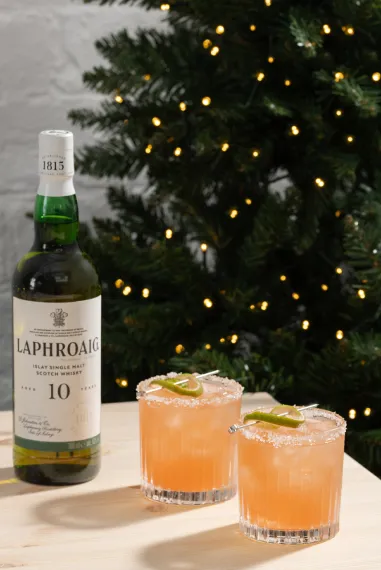 Laphroaig 10 Year Old Whisky next to two drams with Paloma whisky cocktail.