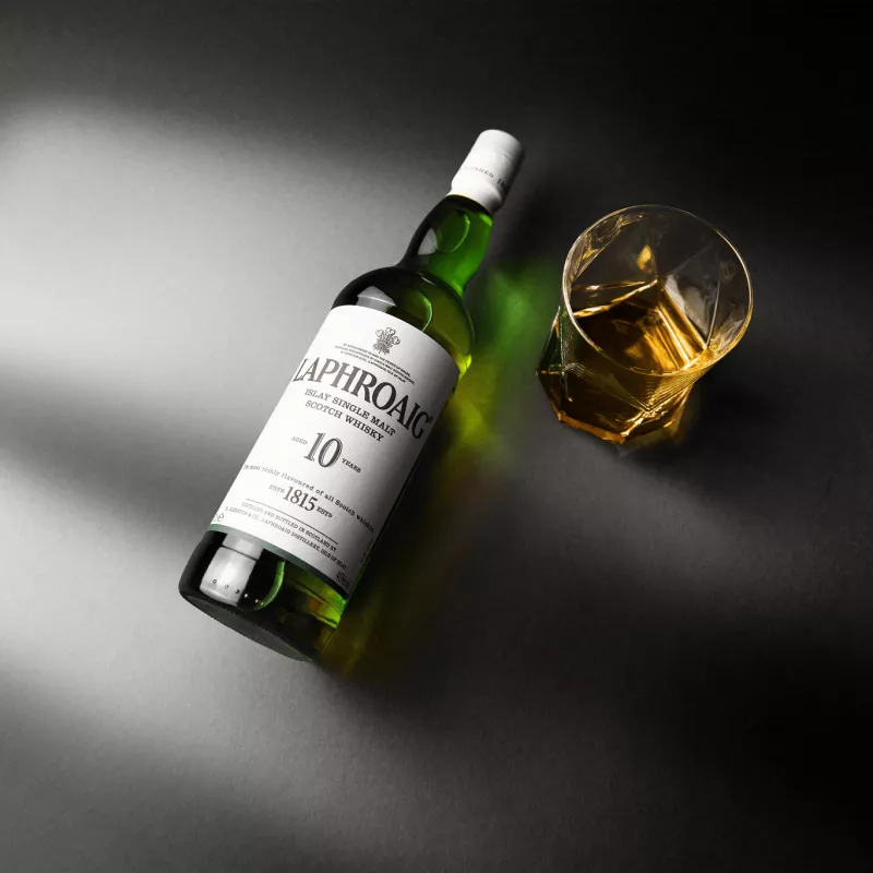 Image of Laphroaig Whisky Iconic 10-year-old bottle with glass filled with it.