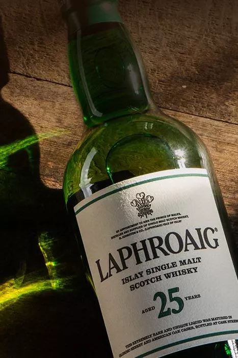 Sunshine hitting a Laphroaig bottle lying on a wooden surface
