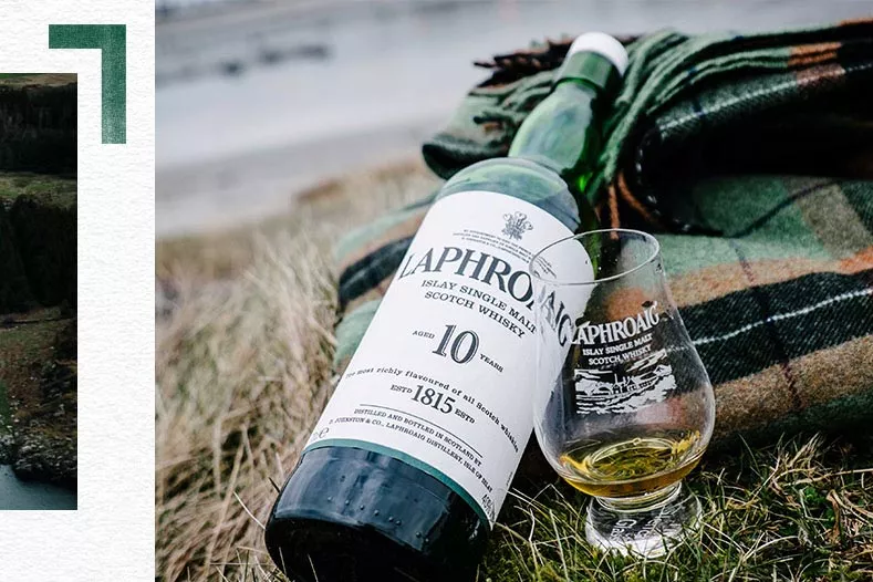 A bottle and a glass of Laphroaig on a picnic blanket in Islay