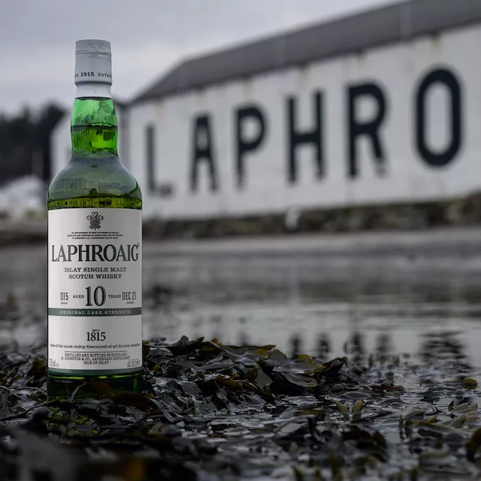Bottle of Laphroaig 10 Cask Strength in front of the Laphroaig building
