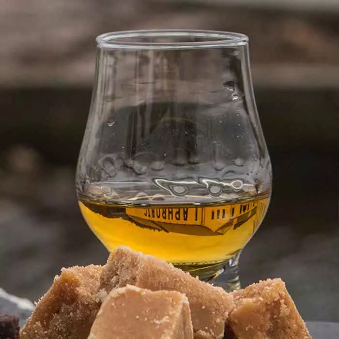 A dram filled with Laphroaig PX Cask next to biscuits