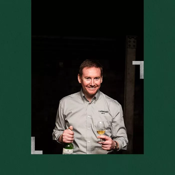 Distillery manager Barry MacAffer holding a bottle and a glass of Laphroaig