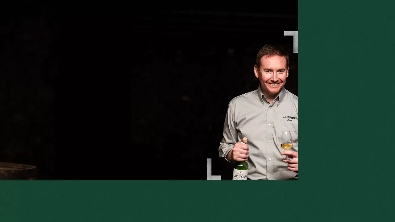 Distillery manager Barry MacAffer holding a bottle and a glass of Laphroaig