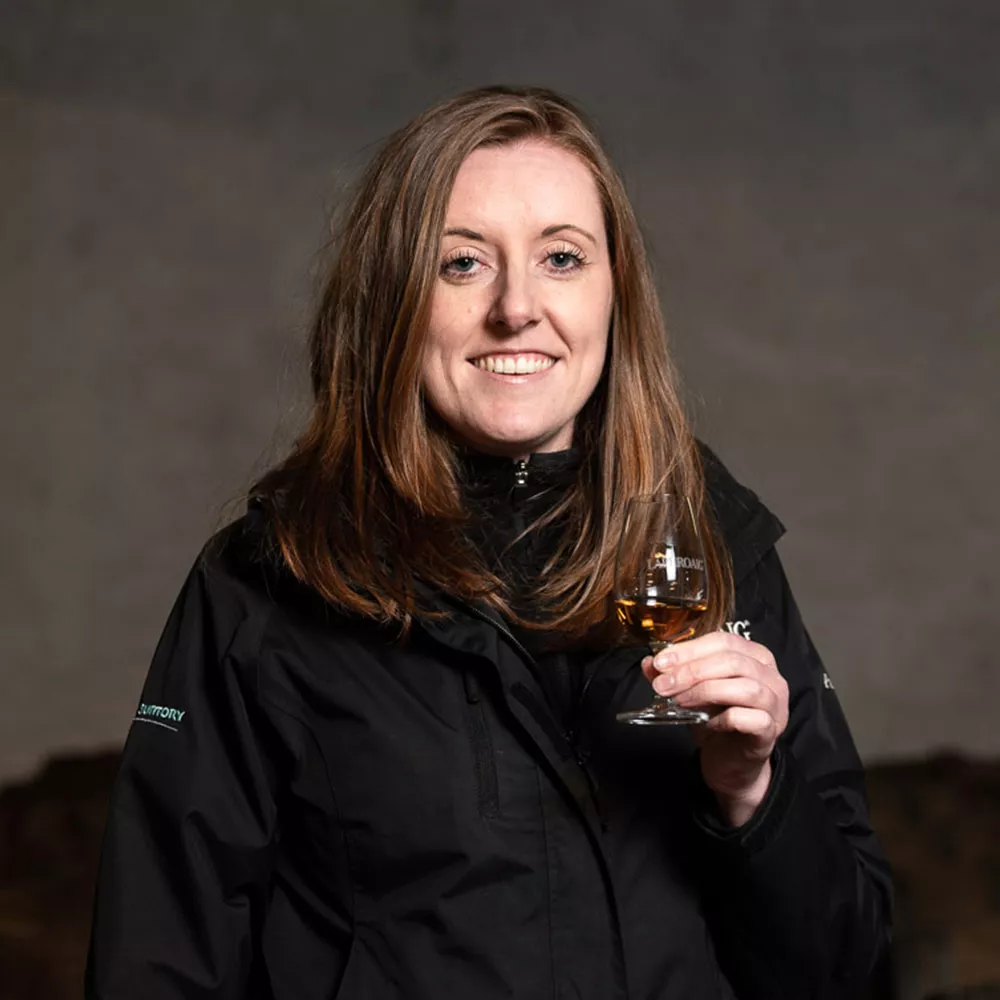 Assistant Manager Pamela Ferguson smiling while holding a filled dram