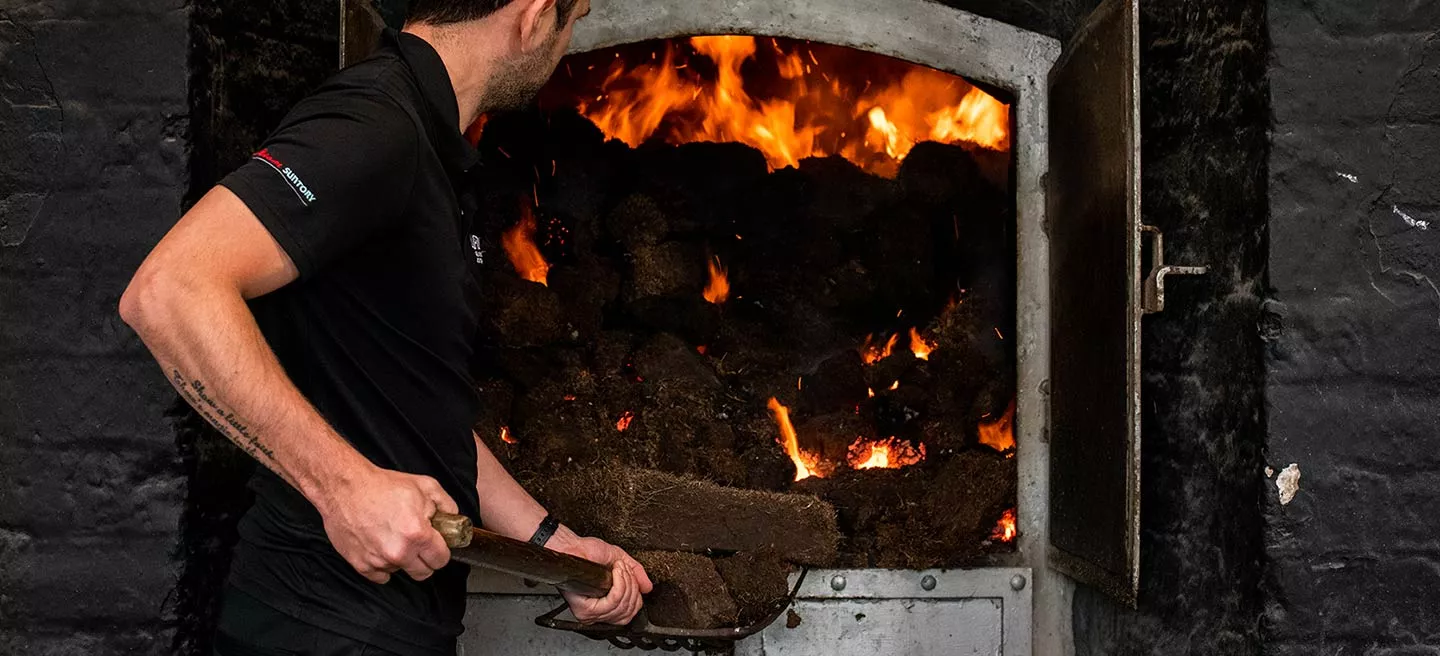 A man shoveling peat into an oven