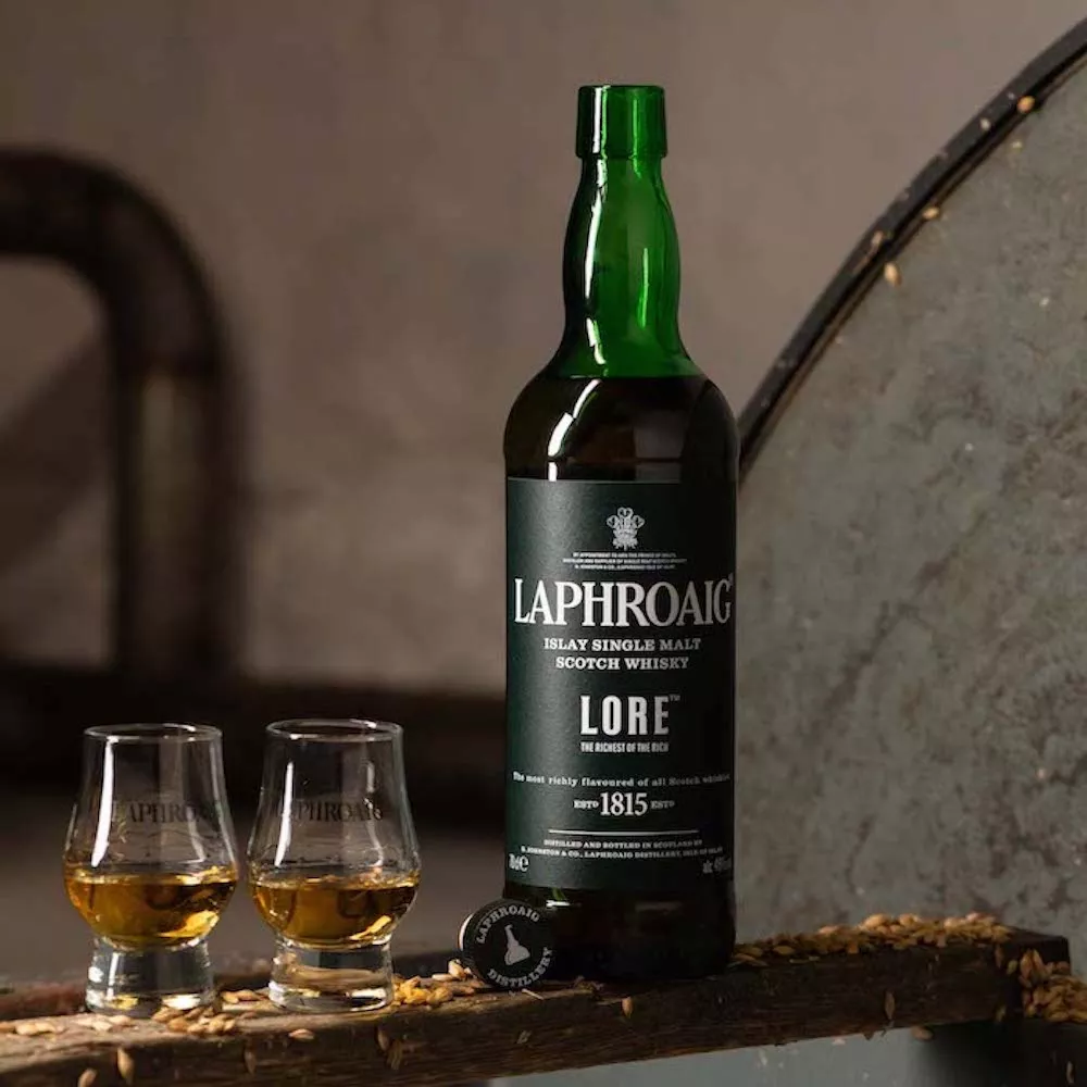 A bottle of Laphroaig whisky Lore next to two drams