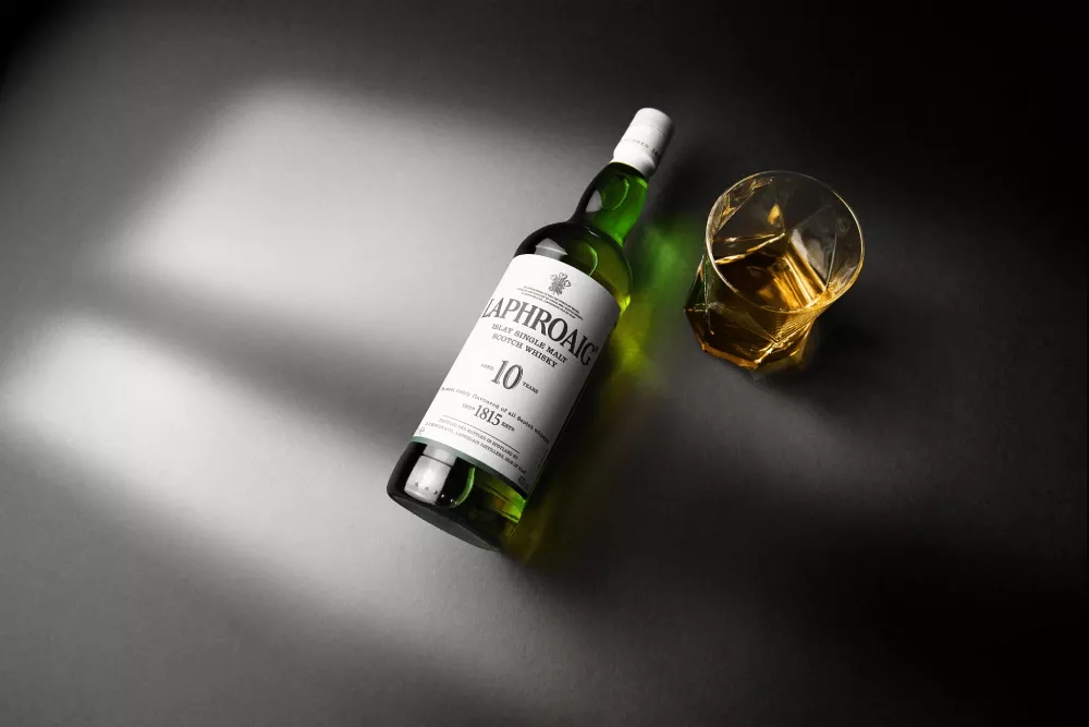 Image of Laphroaig Whisky Iconic 10-year-old bottle with glass filled with it.
