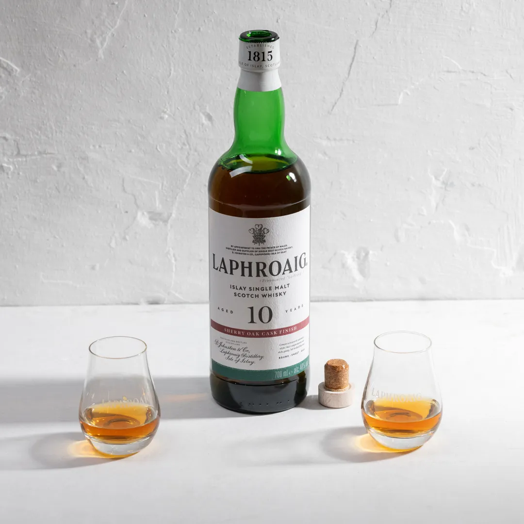 Sherry Oak Laphroaig bottle on a table with two glasses of drams