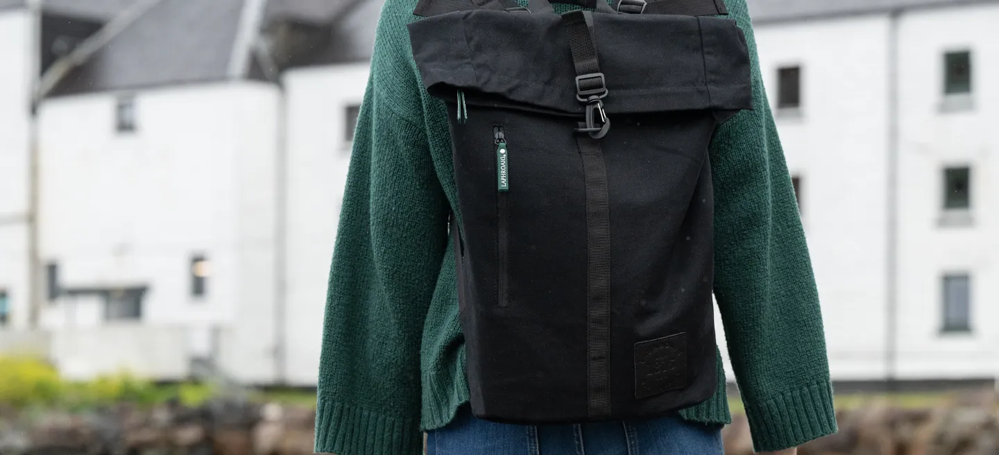 Figure walking towards Distillery wearing a Laphroaig Backpack