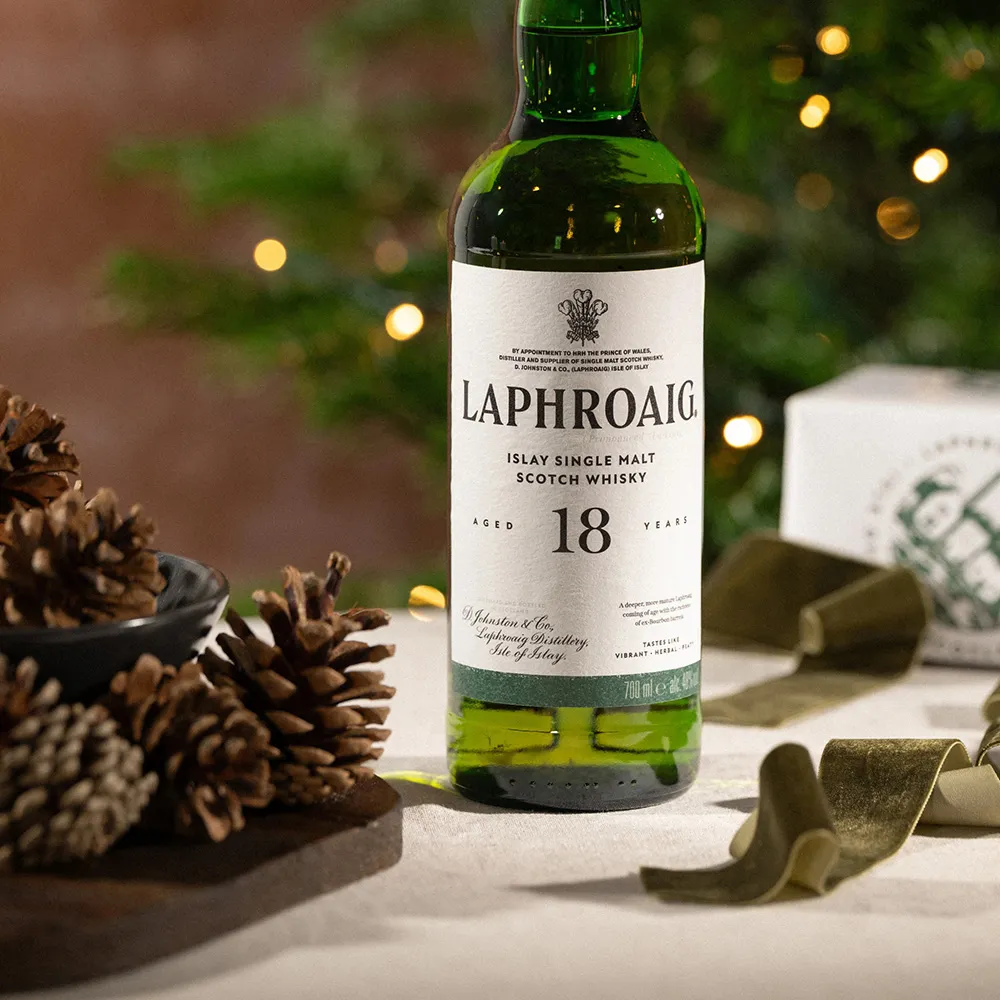 Single Malt Whisky Bottle Festive Table Pinecones Holiday Lights Laphroaig