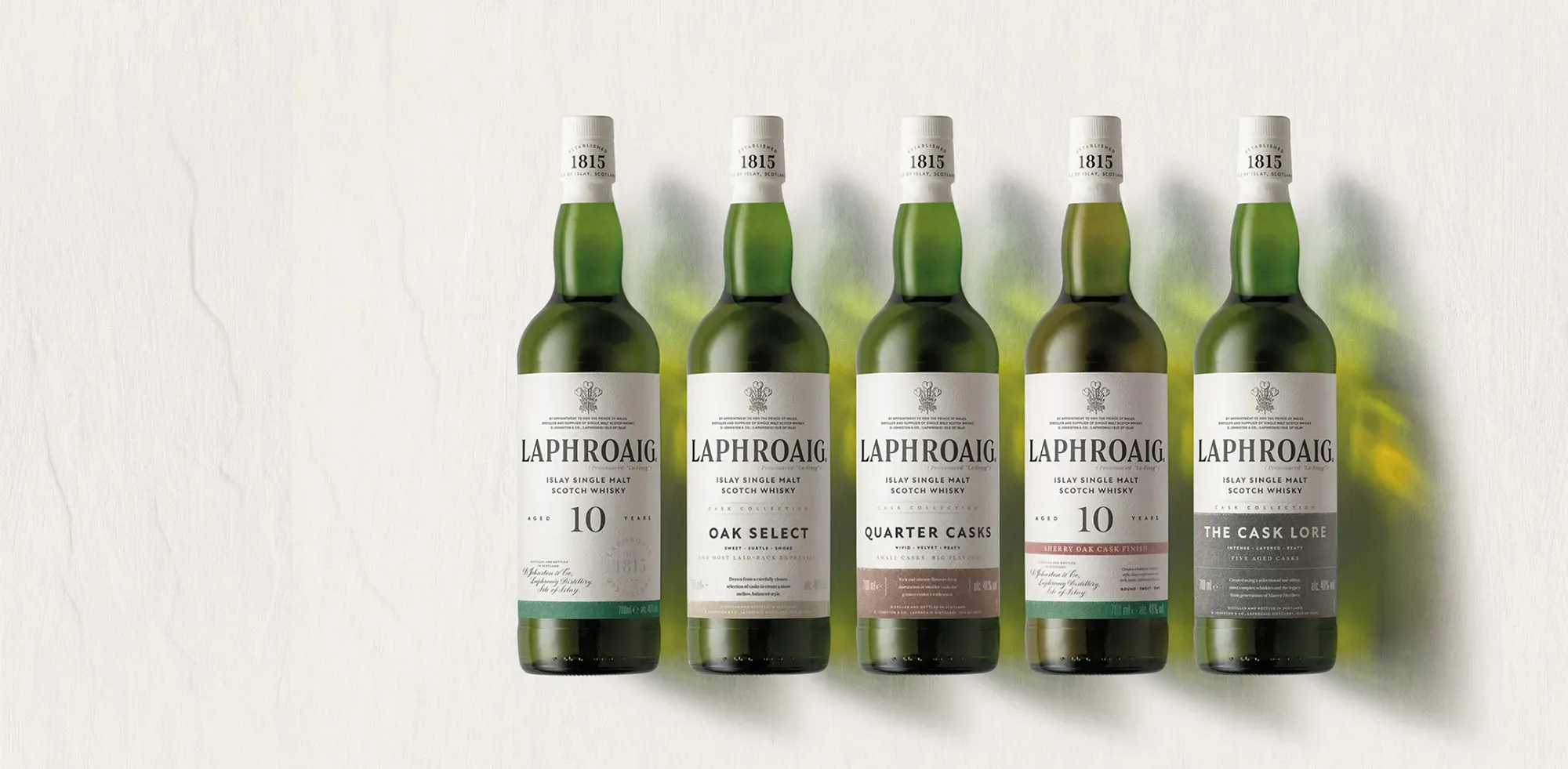 Five Single Malt Whisky Bottles Core Range Lineup Studio Background Laphroaig