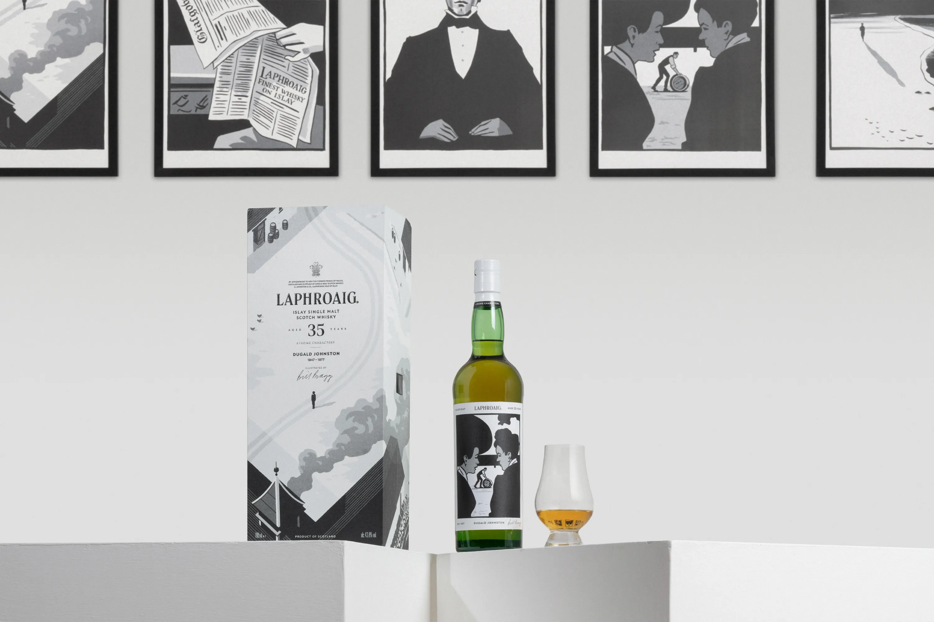 Laphroaig Strong Characters Chapter 2 35-Year-Old whisky, presented with its illustrated packaging and a tasting glass, against a backdrop of framed artwork.