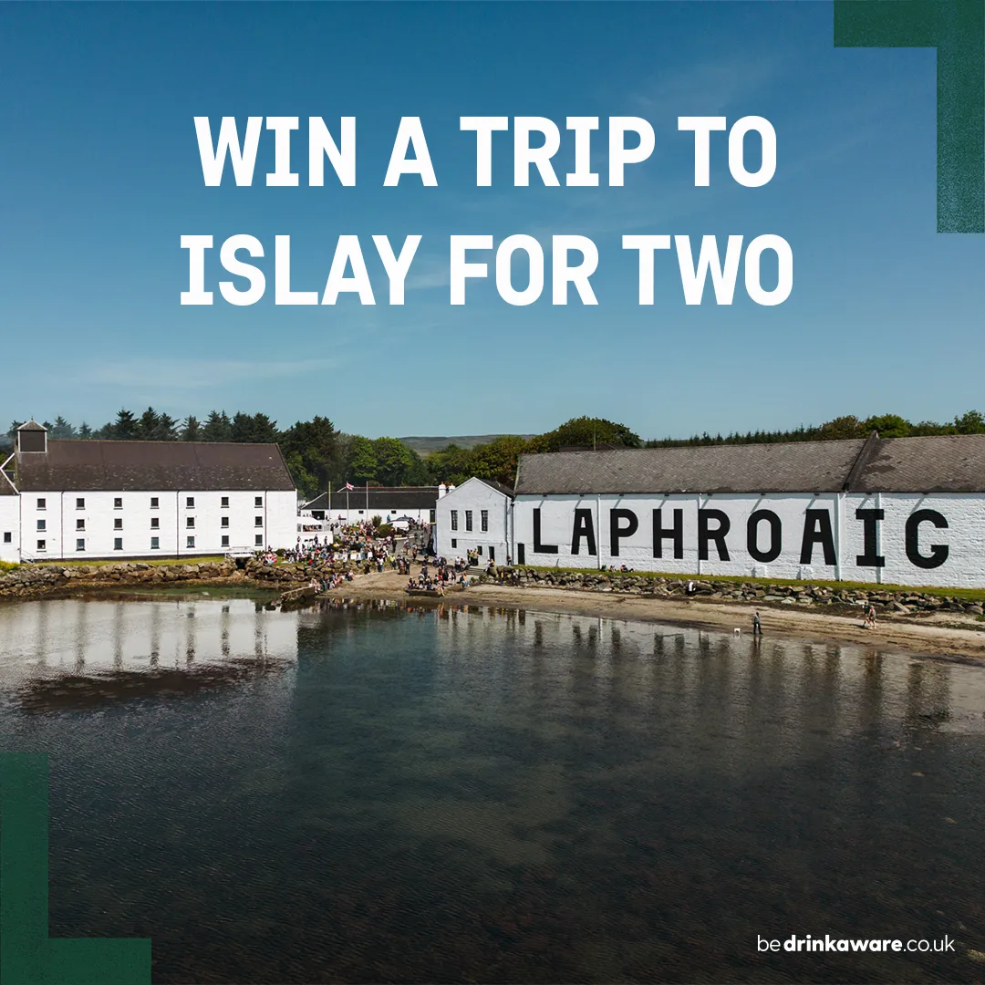 Laphroaig Distillery on the Islay shoreline during Fèis Ìle, with “Win a trip to Islay for two” displayed above.